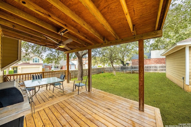 wooden deck with a fenced backyard, ceiling fan, a lawn, and outdoor dining space