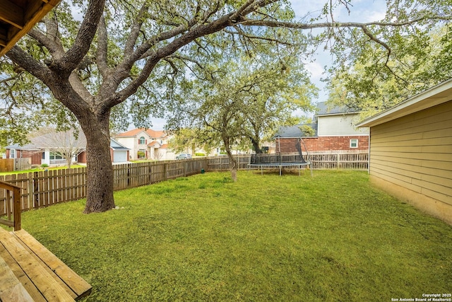 view of yard with a trampoline, a residential view, and a fenced backyard