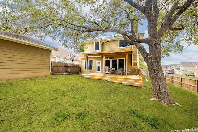 back of property featuring a fenced backyard, a lawn, and a wooden deck