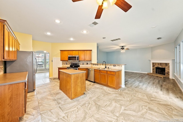 kitchen featuring arched walkways, stainless steel appliances, visible vents, a sink, and a peninsula