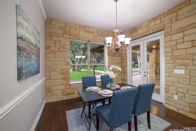 dining space featuring wood-type flooring, a notable chandelier, and french doors