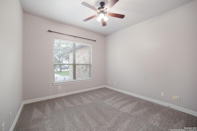 carpeted empty room with a ceiling fan and baseboards