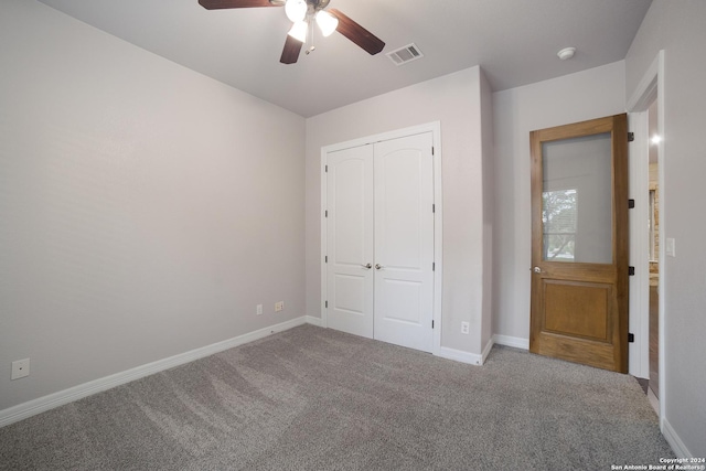 unfurnished bedroom featuring carpet floors, baseboards, visible vents, and a closet