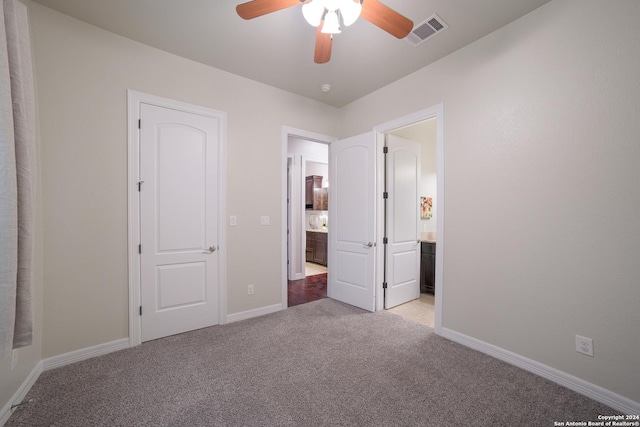 unfurnished bedroom with carpet, visible vents, connected bathroom, and baseboards