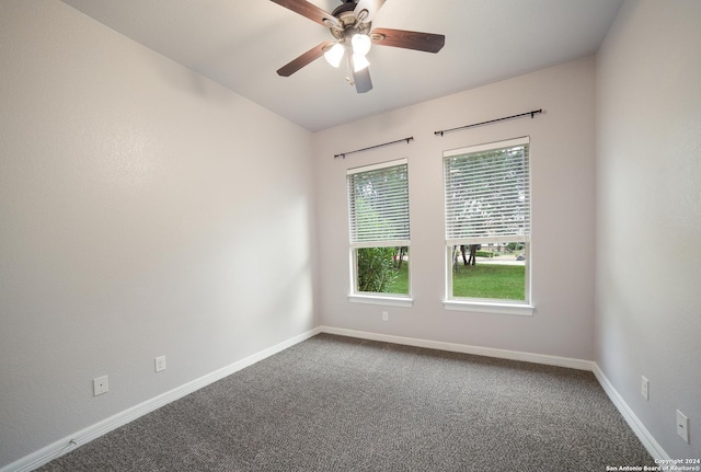 carpeted spare room with a ceiling fan and baseboards