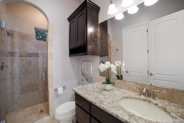 full bathroom featuring a stall shower, vanity, and toilet