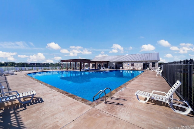 pool with a pergola, fence, and a patio