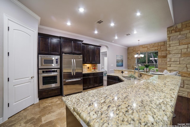 kitchen featuring arched walkways, appliances with stainless steel finishes, a sink, and visible vents