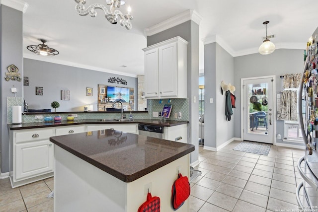 kitchen featuring dark countertops, light tile patterned flooring, crown molding, and a sink