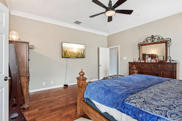 bedroom with baseboards, wood finished floors, visible vents, and crown molding