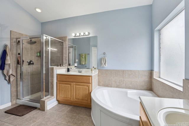 full bathroom featuring a stall shower, tile patterned flooring, two vanities, and a sink