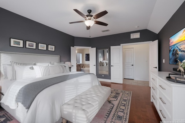 bedroom with lofted ceiling, ceiling fan, ensuite bathroom, wood finished floors, and visible vents