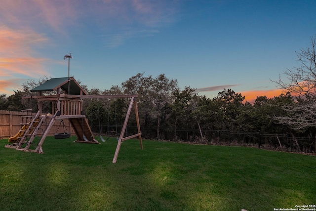 view of playground with a yard and fence