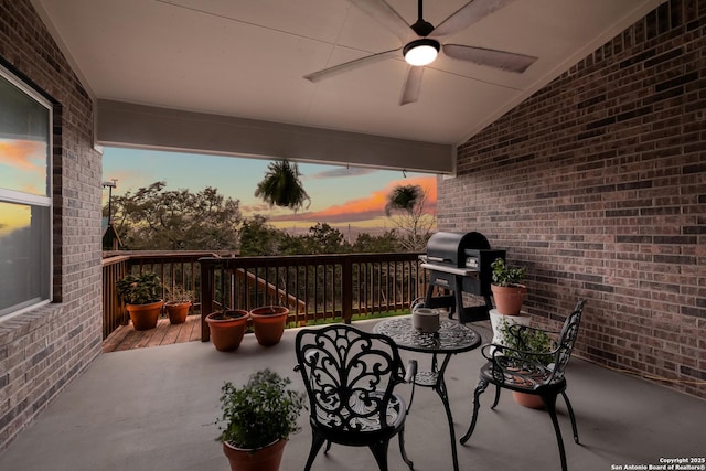 patio terrace at dusk with grilling area and a ceiling fan