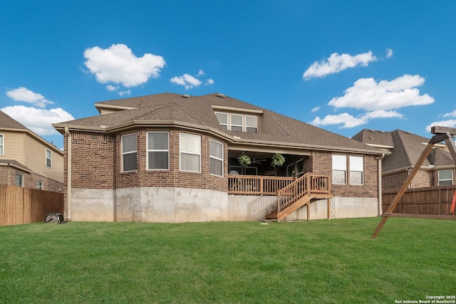 back of property featuring roof with shingles, brick siding, a lawn, and fence