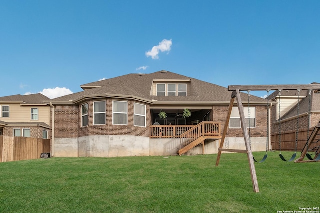 back of property featuring a shingled roof, brick siding, a lawn, and fence