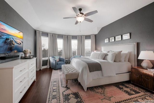 bedroom featuring a textured wall, dark wood-style flooring, and a ceiling fan