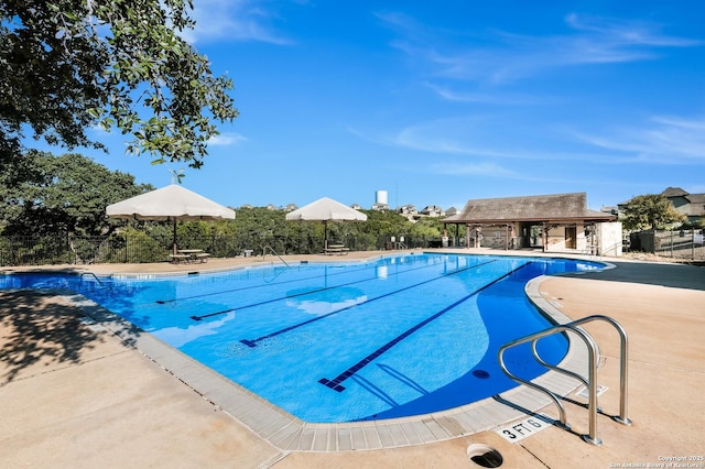 community pool featuring fence and a patio