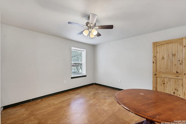 unfurnished room featuring ceiling fan and baseboards