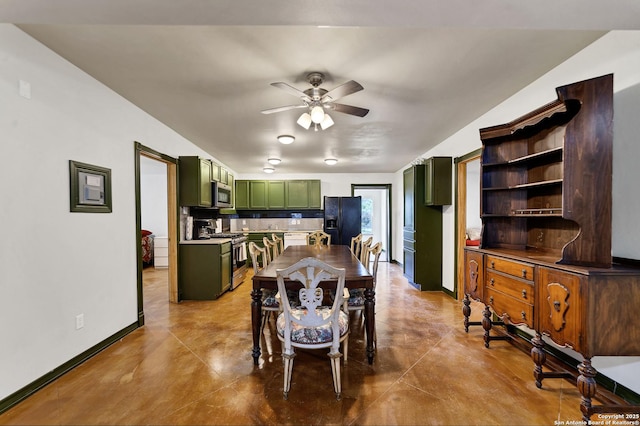 dining room featuring ceiling fan, baseboards, and concrete flooring