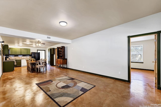 living room with baseboards, visible vents, and a ceiling fan