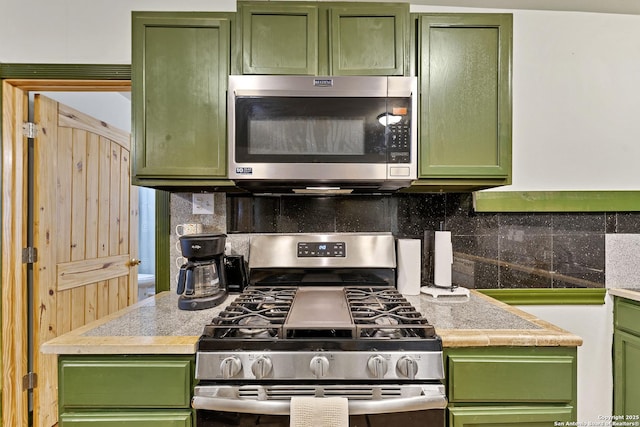 kitchen with appliances with stainless steel finishes and green cabinetry