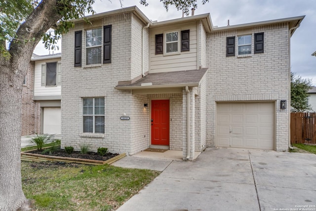 traditional home featuring an attached garage, fence, concrete driveway, and brick siding