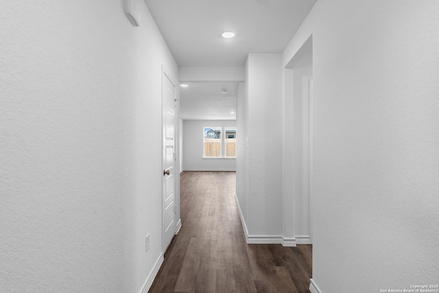 hallway featuring dark wood-style floors and baseboards