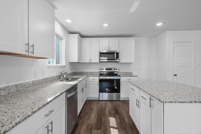 kitchen with white cabinets, dark wood-style floors, stainless steel appliances, and a sink