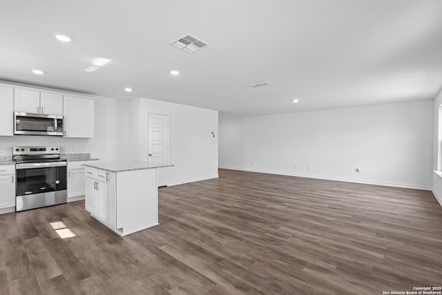 kitchen featuring stainless steel appliances, dark wood-type flooring, visible vents, and a center island