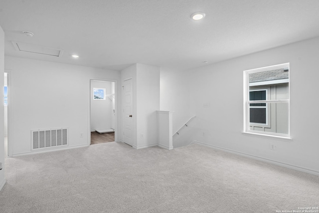 carpeted empty room with baseboards, recessed lighting, visible vents, and attic access