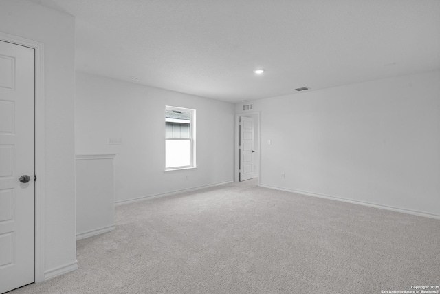 empty room with carpet floors, baseboards, visible vents, and recessed lighting