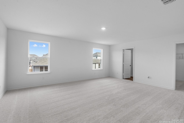 carpeted empty room featuring visible vents and baseboards