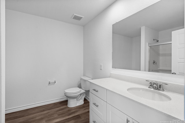 full bathroom with toilet, wood finished floors, vanity, visible vents, and baseboards
