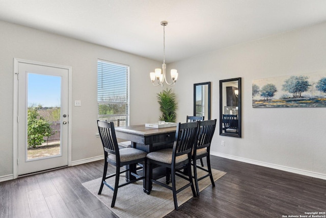 dining area featuring a chandelier, baseboards, and dark wood-style floors