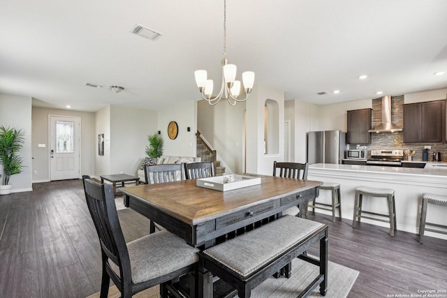 dining area with a notable chandelier, visible vents, baseboards, stairs, and dark wood-style floors