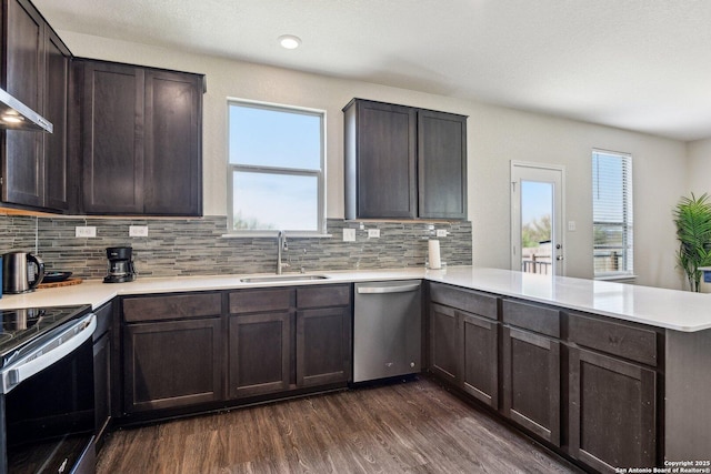 kitchen featuring tasteful backsplash, a peninsula, stainless steel appliances, light countertops, and a sink