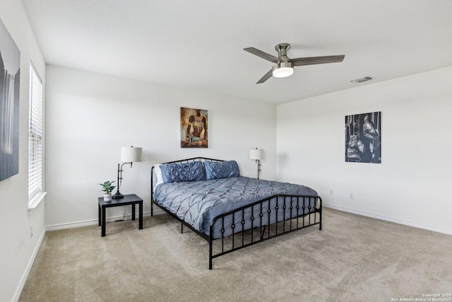 carpeted bedroom featuring multiple windows, visible vents, and baseboards