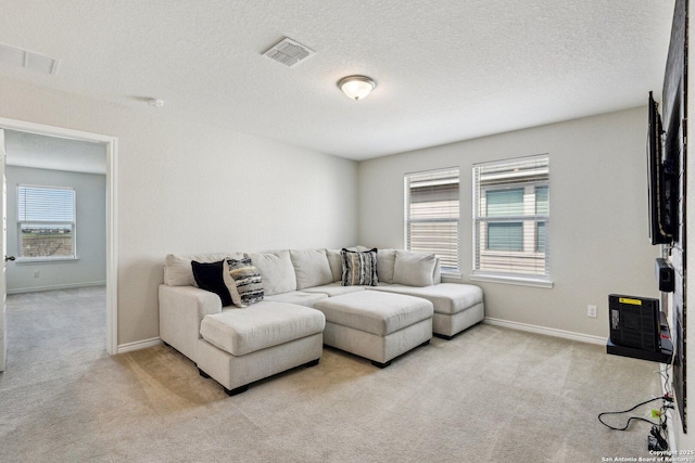 carpeted living area featuring visible vents, a textured ceiling, and baseboards