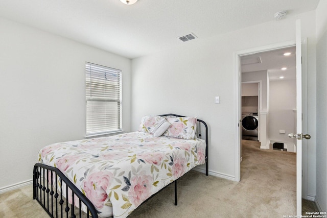 bedroom with washer / dryer, baseboards, visible vents, and light colored carpet