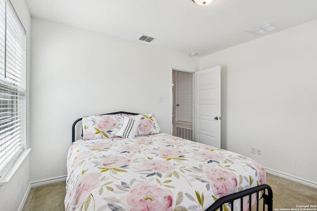 bedroom with carpet, visible vents, and multiple windows