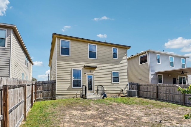 back of property with a fenced backyard and central air condition unit