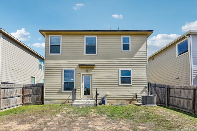 rear view of property with entry steps, central AC unit, and a fenced backyard