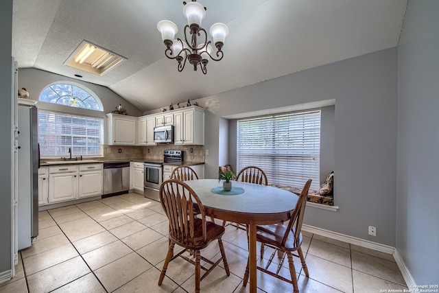 dining room with light tile patterned floors, lofted ceiling, a textured ceiling, a chandelier, and baseboards