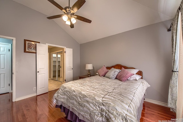 bedroom with a ceiling fan, high vaulted ceiling, baseboards, and wood finished floors