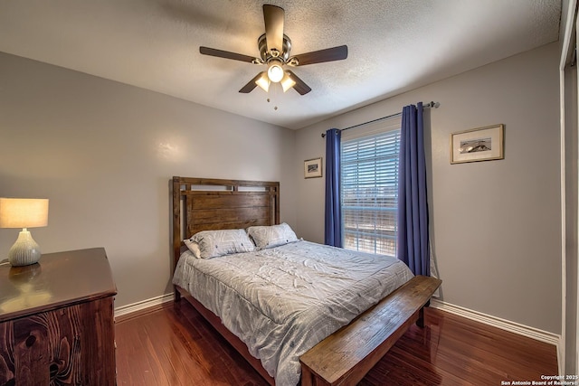 bedroom with a textured ceiling, wood finished floors, a ceiling fan, and baseboards