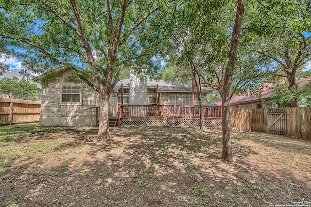 back of house with a fenced backyard, brick siding, and a deck