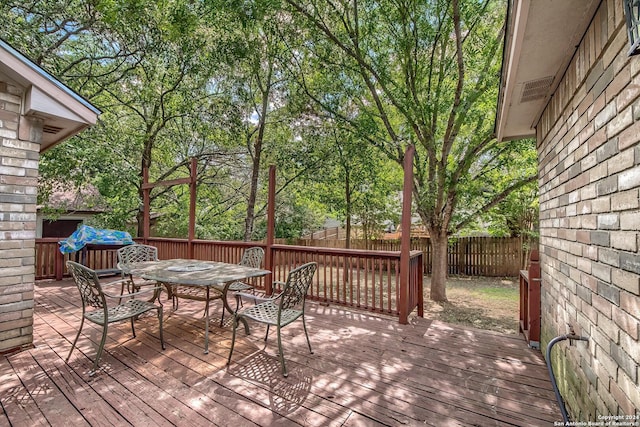 wooden deck with outdoor dining space and a fenced backyard