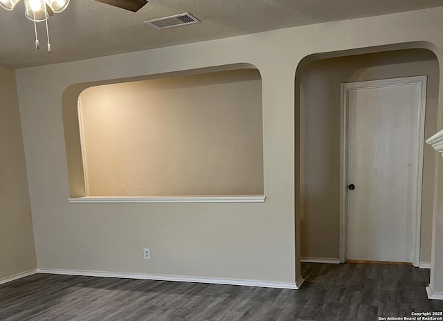 empty room with baseboards, wood finished floors, visible vents, and a ceiling fan