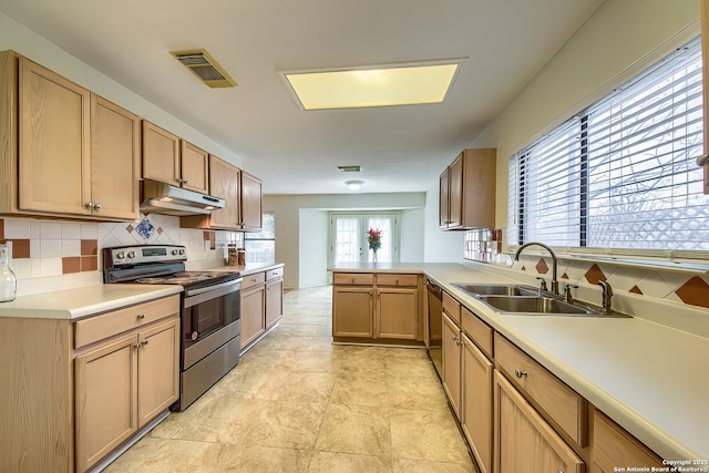 kitchen with under cabinet range hood, stainless steel appliances, a sink, visible vents, and backsplash